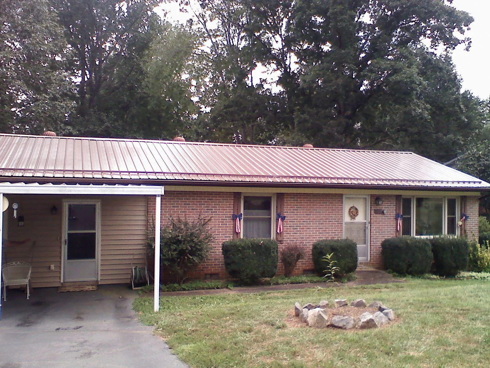 Bronze metal roof and carport on a brick ranch home — Roof Repair work by our crew in Marshfield